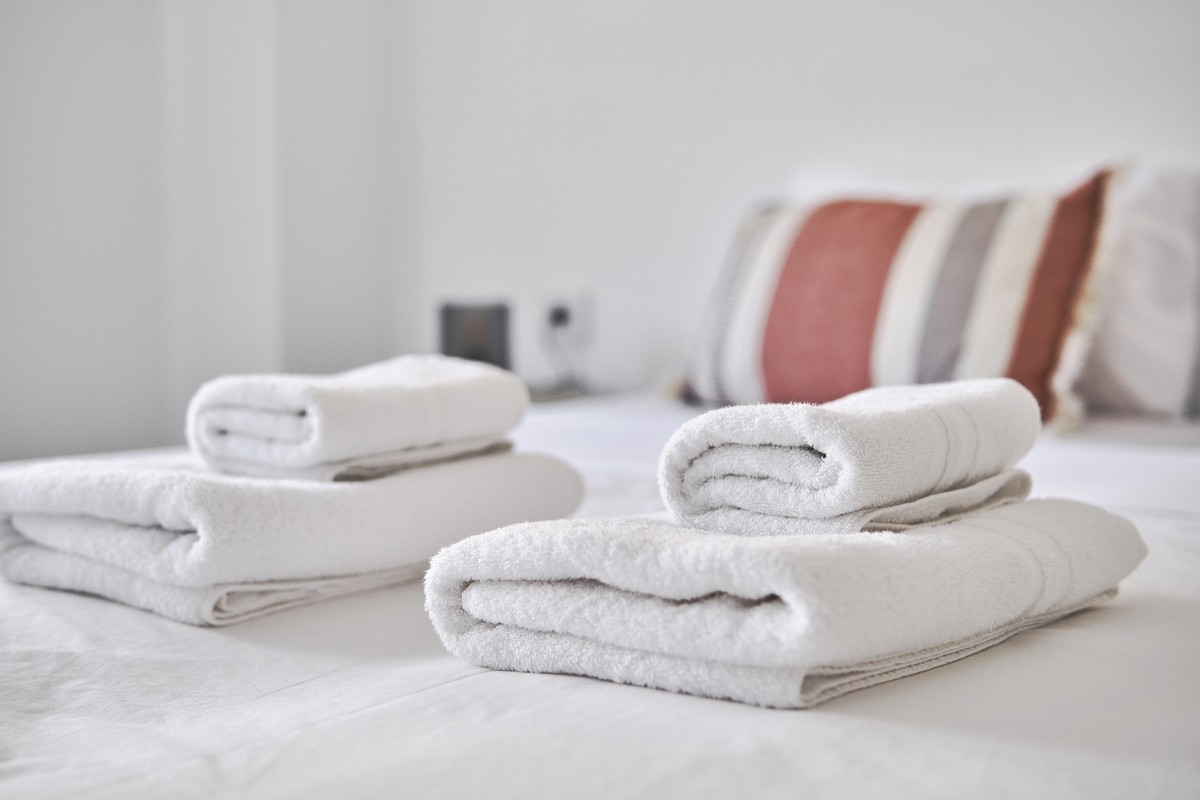 Fresh towels provided on a bed in holiday accommodation.